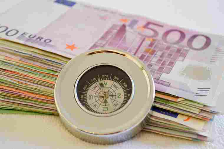 Geldscheine mit eine Kompass davor