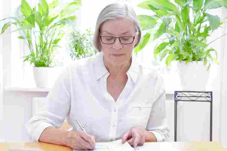 Ältere Dame bearbeitet Unterlagen